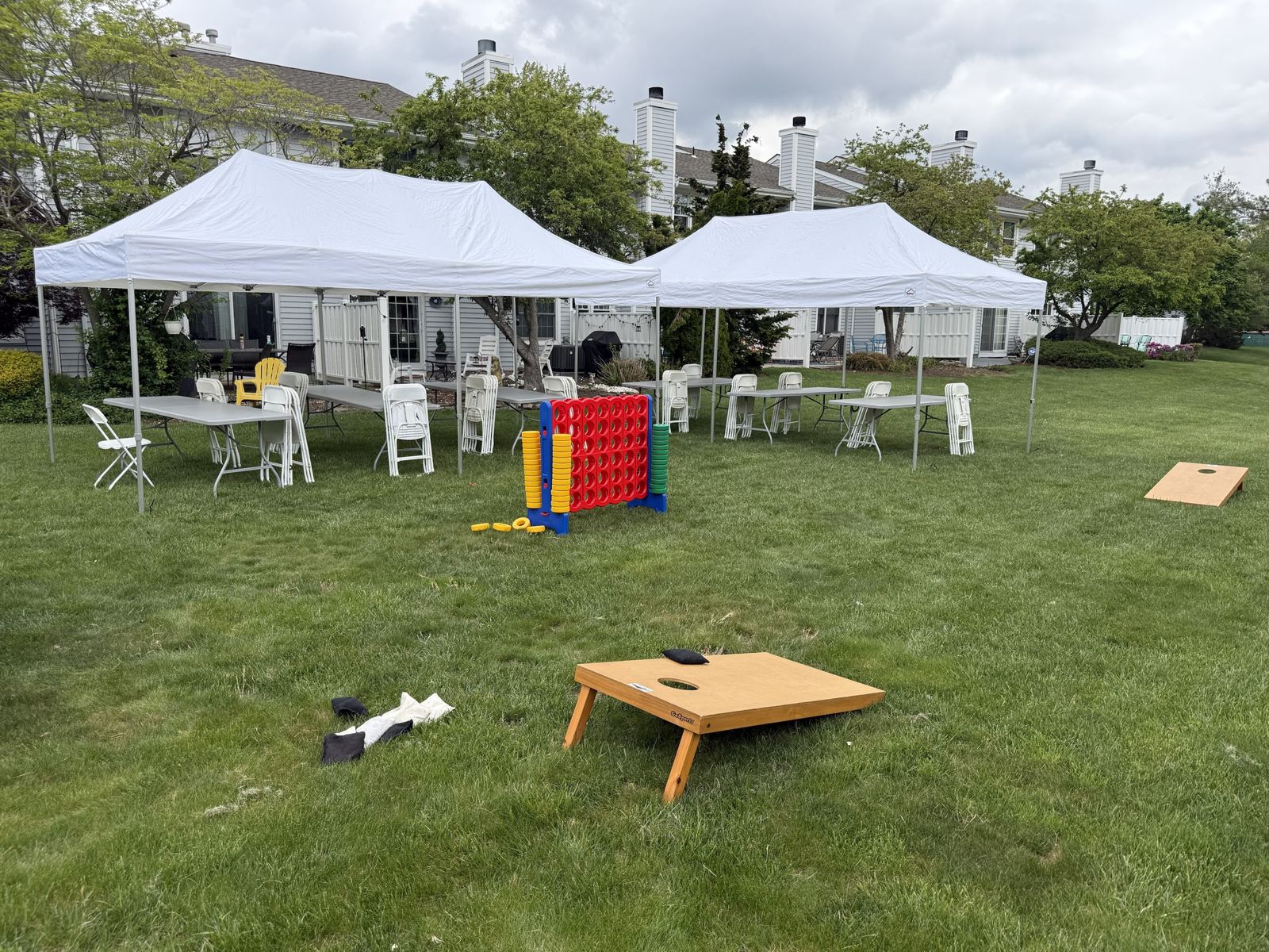 Two 10×20 canopy tents over banquet tables and chairs on a lawn